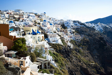 Santorini's Iconic Cliffside with White Buildings and Blue Domes - obrazy, fototapety, plakaty