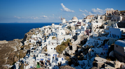 Iconic Greek Landscape, a Cliffside with White Buildings and Blue Domes - obrazy, fototapety, plakaty