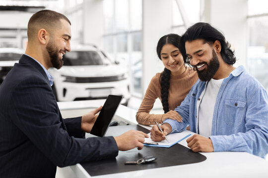 Wealthy millennial indian family buying new car in showroom