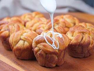 Dripping glaze on cinnamon roll.