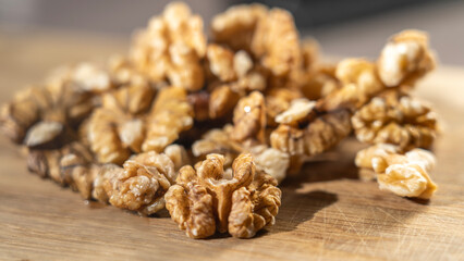 Obraz premium Peeled walnut kernels close-up on wooden background, Selective focus, tinted image.