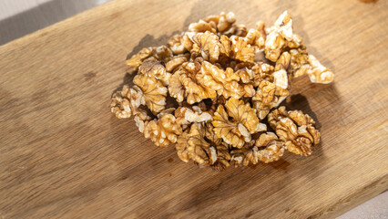 Obraz na płótnie Canvas Peeled walnut kernels close-up on wooden background, Selective focus, tinted image.