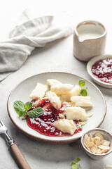Lazy dumplings, vareniki with raspberry jam decorated with almond petals and mint leaves. Boiled...