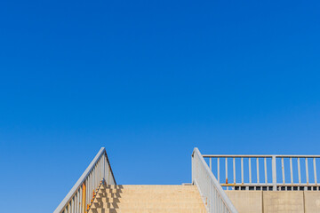 Upwards Shot of a Stairway Staircase Leading Up to the Clear Blue Sky, Pedestrian Bridge in the...