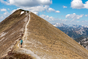 Hiker woman on idyllic hiking trail on alpine meadow with scenic view of majestic Hochschwab...