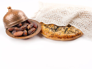 Pide and date fruits, islam religion holy month concept Ramazan bread called pide and date fruits. Isolated white studio background. Copy space. Round fresh baked hot bread.