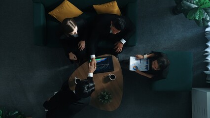 Top down aerial view of skilled business man handed out business document to investor while manager placed tablet display financial statistic graph on table and shake hand with manager. Directorate. © InfiniteFlow