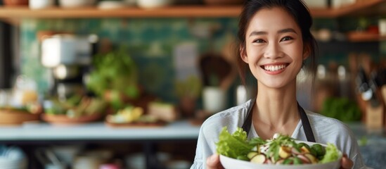 Healthy young woman smiling and holding a delicious fresh salad bowl outdoors