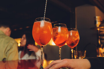 Campari tonic alcoholic cocktail with red bitter, tonic, lime and ice. Old wooden table background,...