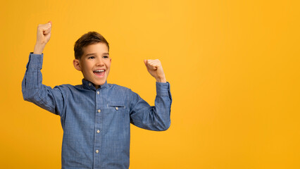Yes. Overjoyed Teen Boy Shaking Fists, Celebrating Success Over Yellow Studio Background