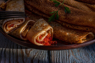 Pancake stuffed with red caviar. Traditional Russian dish is pancakes with red caviar