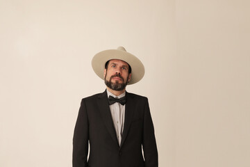 Portrait of thoughtful mature man wearing hat looking away and poses indoor.