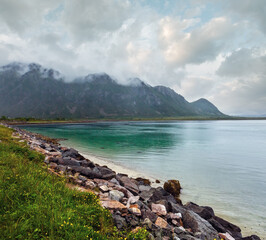 Lofoten fjords and lakes cloudy landscape with sandy beach, lough, and mountains (Norway). Summer polar day night view.