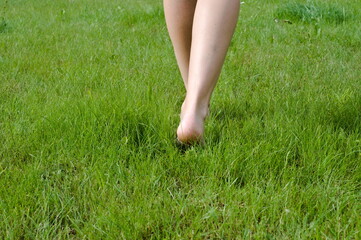 woman legs on the green grass