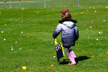 Young child during an Easter Egg Hunt in the small town of Windsor in Upstate NY.  Young girl runs...