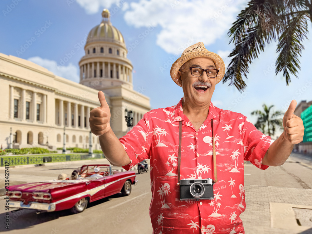 Sticker happy male tourist with a camera gesturing thumbs up in cuba