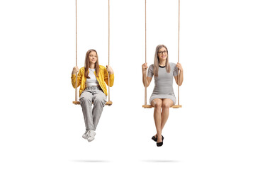 Mother and teenage daughter sitting on swings