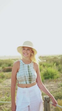 Vertical video of a portrait beautiful young woman smiling at the camera on a sunny summer day. Enjoying her holiday during the travel. Concept of summer holidays, weekend and happiness