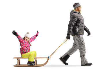 Full length profile shot of a father pulling a happy little girl on a wooden sled