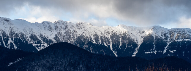 Panoramic view over Piatra Craiului mountain ridge in winter. Romanian mountains in winter. Snow covered Carpathians.