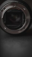 A close-up image showcases the intricate interior of a professional camera lens against a sleek black backdrop. The lens's complex components and finely detailed construction are revealed.