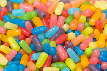 Many brightly colored jelly beans in a rainbow of pastel colors. Popular candy for Easter.