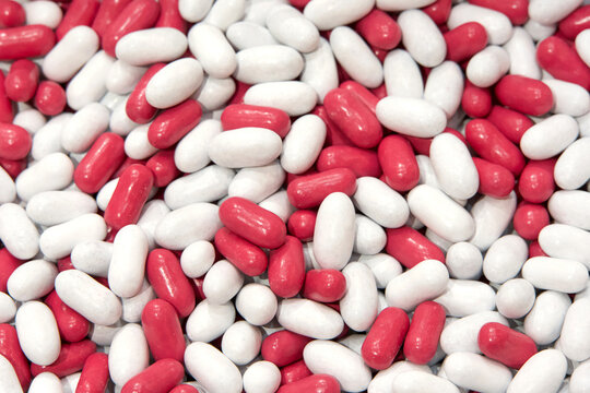 Close up on background of white and pink candy coated licorice treats.