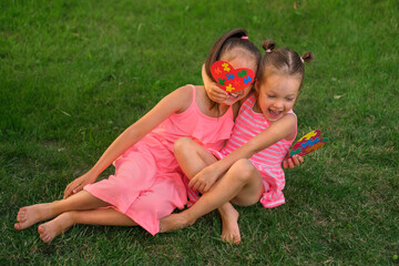 Funny kids with autism syndrome are messing around on the lawn in the park