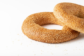 Two traditional turkish simit bagels with sesame seeds closeup on white