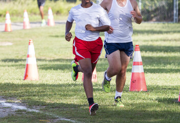 Young high school boys running in a 5K cross country race on grass