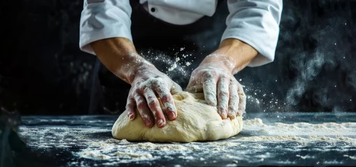 Selbstklebende Fototapeten Hands kneading bread dough. Baking concept. Hard working male prepares pastry by himself, kneads dough on wooden counter with flour. Male cook bakes bread or delicious bun © Nataliia_Trushchenko