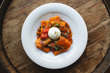 Appetizing Italian paccheri pasta with tomato sauce and cheese.