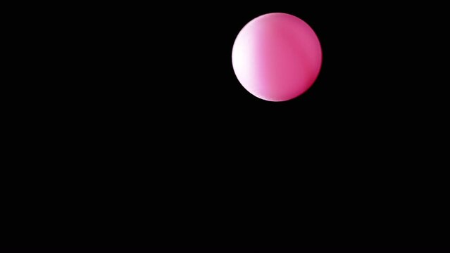 Rotating Pink Ball or Sphere Flies in Blank Space on a Black Background. Abstract. Plastic ball moves slowly across the screen, and balances in air flow. Levitation. Selective focus. Side lighting.