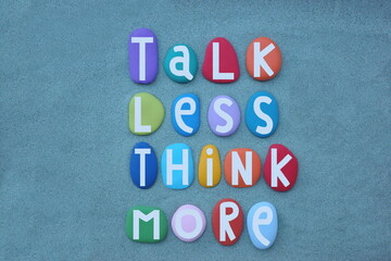 Talk less think more, creative slogan composed with hand painted multi colored stone letters over...