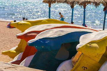 Aqaba, Jordan, a close up view of several colourful catamarans folded on one side on the beach, at...