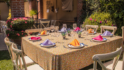 A Mexican Table Setting for a Casual breakfast, lunch or dinner on the house garden. The table is...