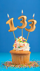 Birthday cupcake with candle number 133 - Blue background