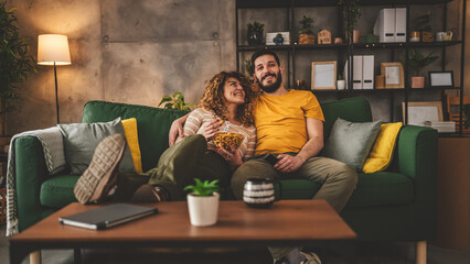 Couple caucasian man and woman sit at home on sofa bed watch tv movie - obrazy, fototapety, plakaty