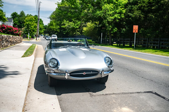 collectible Convertible Jaguar E Type parked on the side of the road.