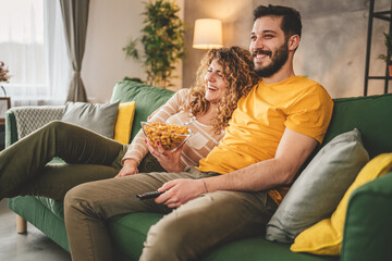 Couple caucasian man and woman sit at home on sofa bed watch tv movie