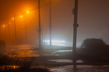 Orange street lights in heavy fog and cars drive by. Long exposure, blurred cars and light lines...