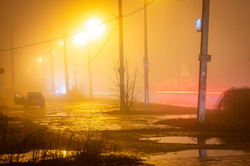 Orange street lights in heavy fog and cars drive by. Long exposure, blurred cars and light lines...