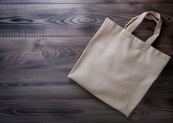 Advertising shot of beige linen shopper, shopping bag lying on dark wooden surface, top view