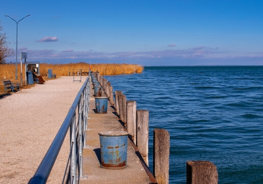 Wooden pier on the beach with metal bannister