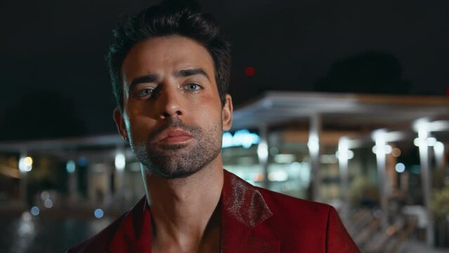 Masculine man looking camera with seductive gaze in night city close up portrait