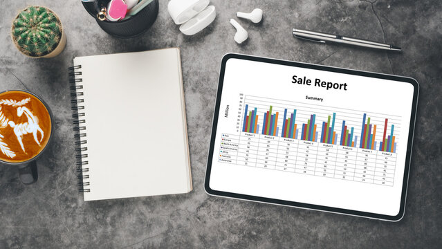 Business analytics concept, Modern tablet displaying a vibrant sales report with bar graphs on a desk with coffee, notebook, and stationery, portraying an efficient work environment.