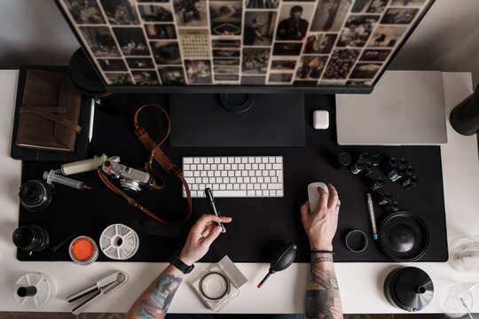 Overhead view of a photographer's desk, showcasing an array of professional photography equipment and tools, reflecting a blend of technology and art