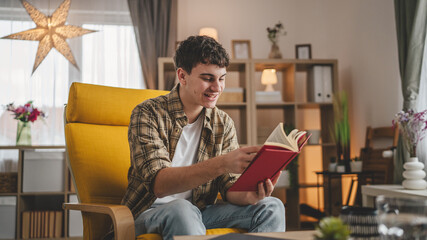 Young man caucasian teenager read book study at home education concept