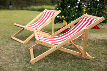 red and white striped deckchairs on green grass on backyard.