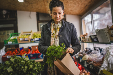 Woman grocery shopping at the local store with paper bag